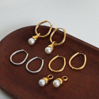 five pairs of earrings on a wooden tray