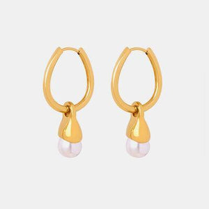 a pair of gold hoop earrings with pearls