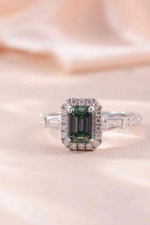 a ring with a green stone surrounded by diamonds