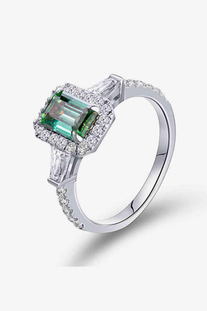 an emerald and diamond ring on a white background