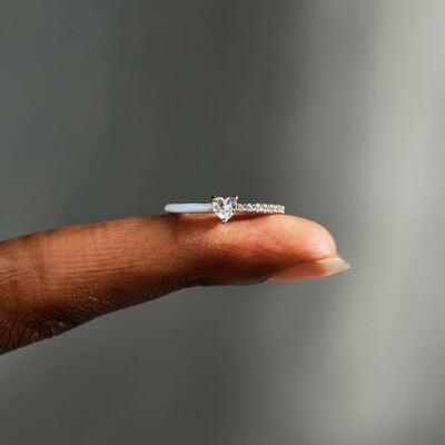 a woman's hand holding a diamond ring