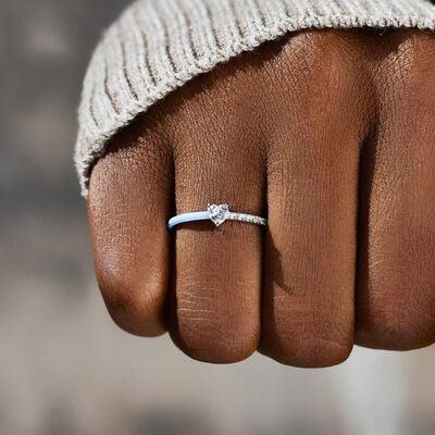 a person's hand with a diamond ring on it