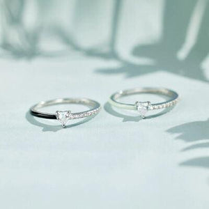 a pair of silver rings sitting on top of a table