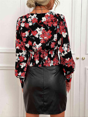 a woman wearing a floral blouse and black leather skirt
