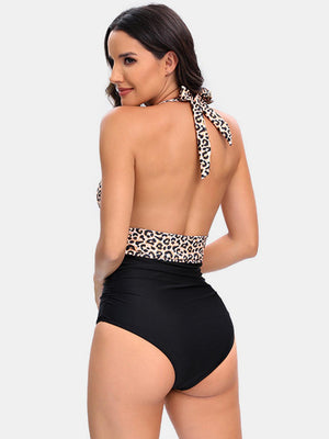 a woman in a black swimsuit with a leopard print halter