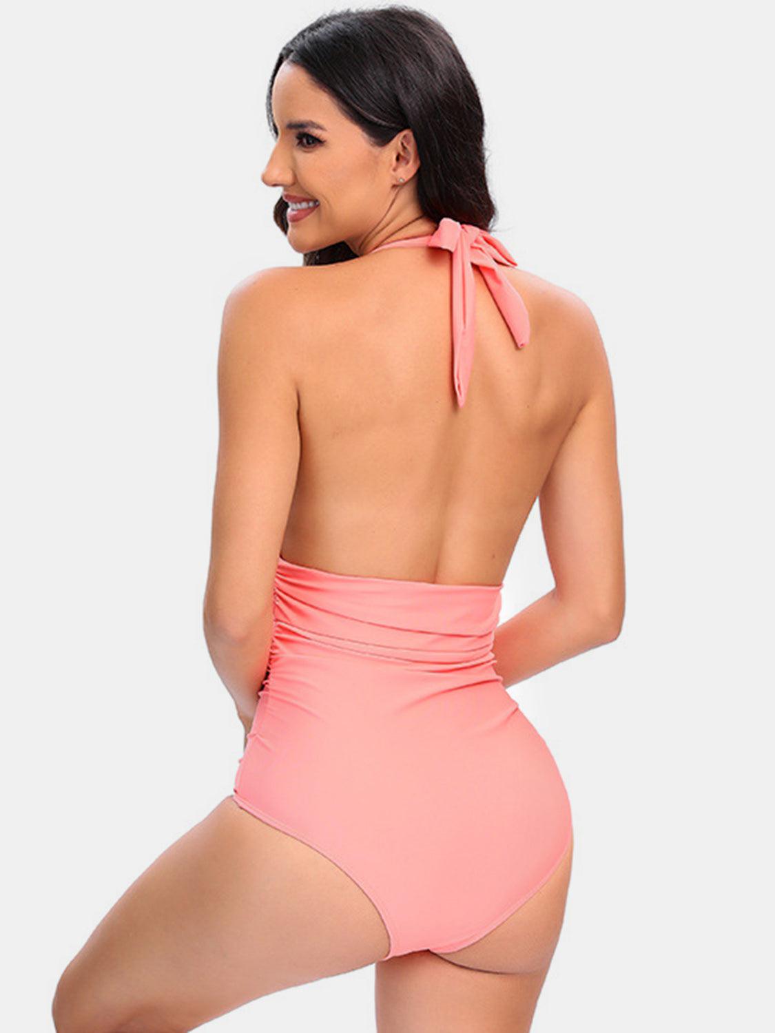 a woman in a pink one piece swimsuit