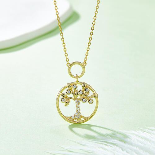 a gold necklace with a tree of life pendant