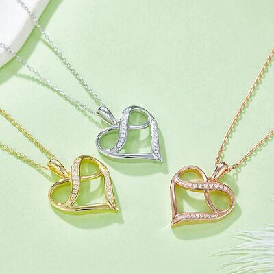 three necklaces on a green surface with a white feather