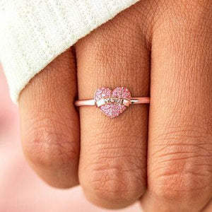 a close up of a person's hand with a heart shaped ring