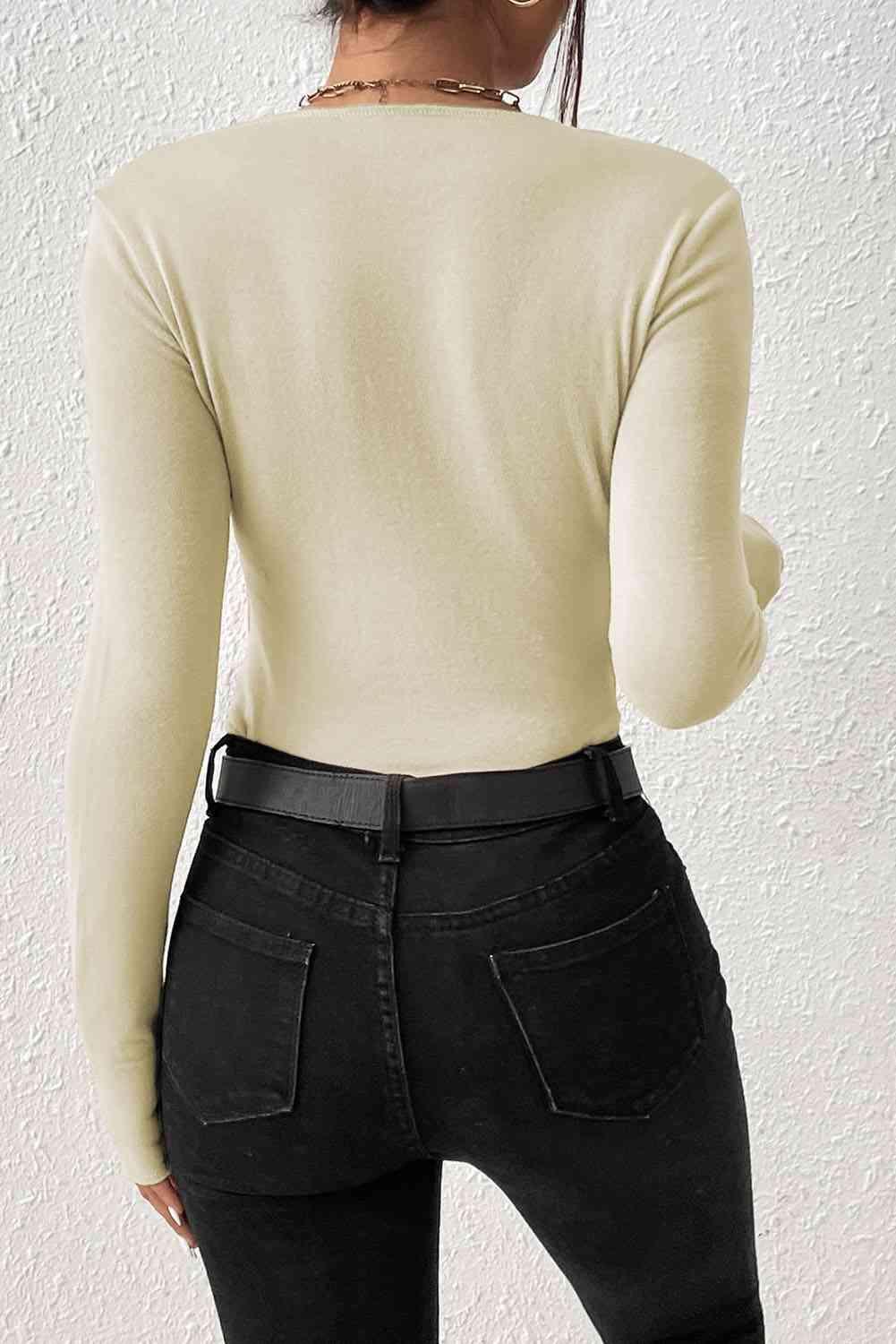 a woman wearing a white sweater and black jeans