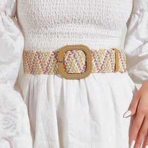 a woman wearing a white dress and a gold belt