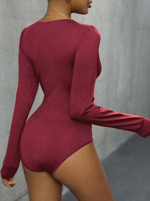 a woman in a red bodysuit is posing for the camera