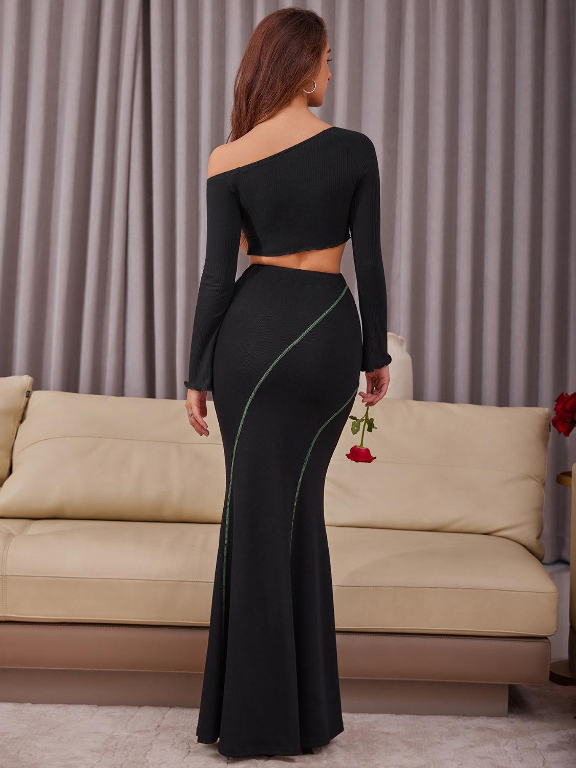 a woman in a black dress standing in front of a couch