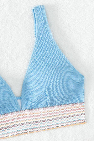 a blue bikini top with a striped bottom