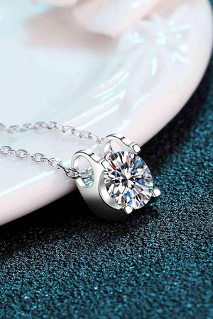 a diamond pendant on a chain on a plate