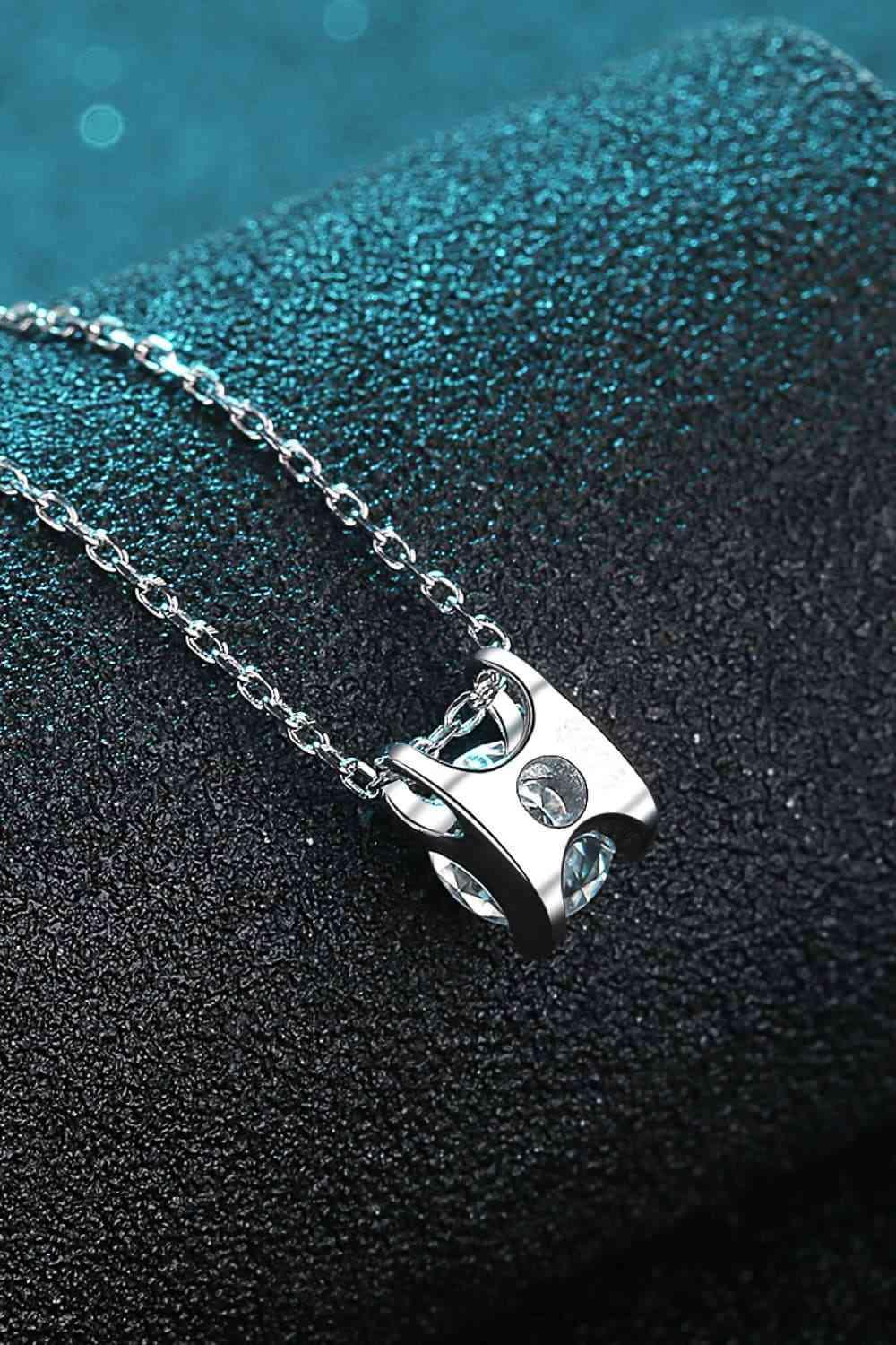 a silver necklace with a cat on it