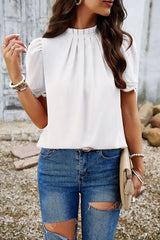 a woman wearing ripped jeans and a white top