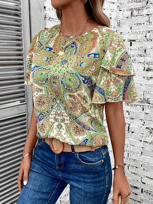 a woman wearing a top with a paisley pattern