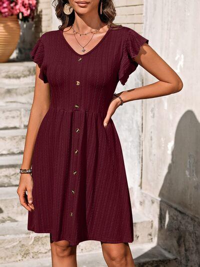 a woman in a maroon dress standing on steps