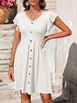 a woman wearing a white dress with buttons