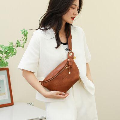 a woman holding a brown purse standing next to a toilet