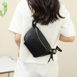 a woman wearing a white shirt holding a black purse