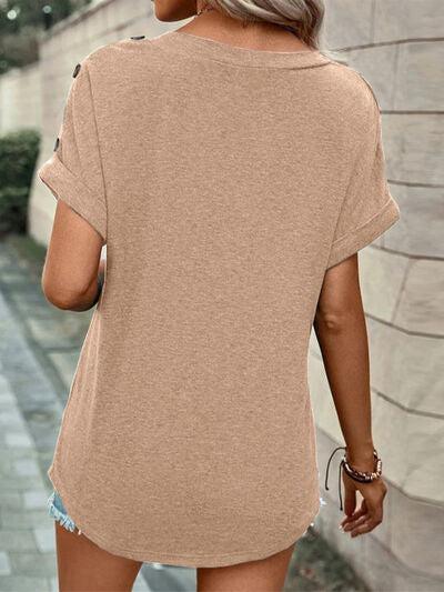 a woman walking down a street wearing a tan top