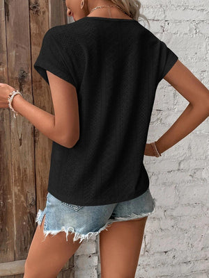 a woman wearing a black shirt and ripped shorts