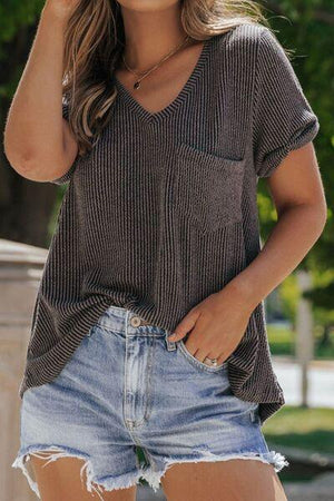 a woman wearing a brown shirt and denim shorts