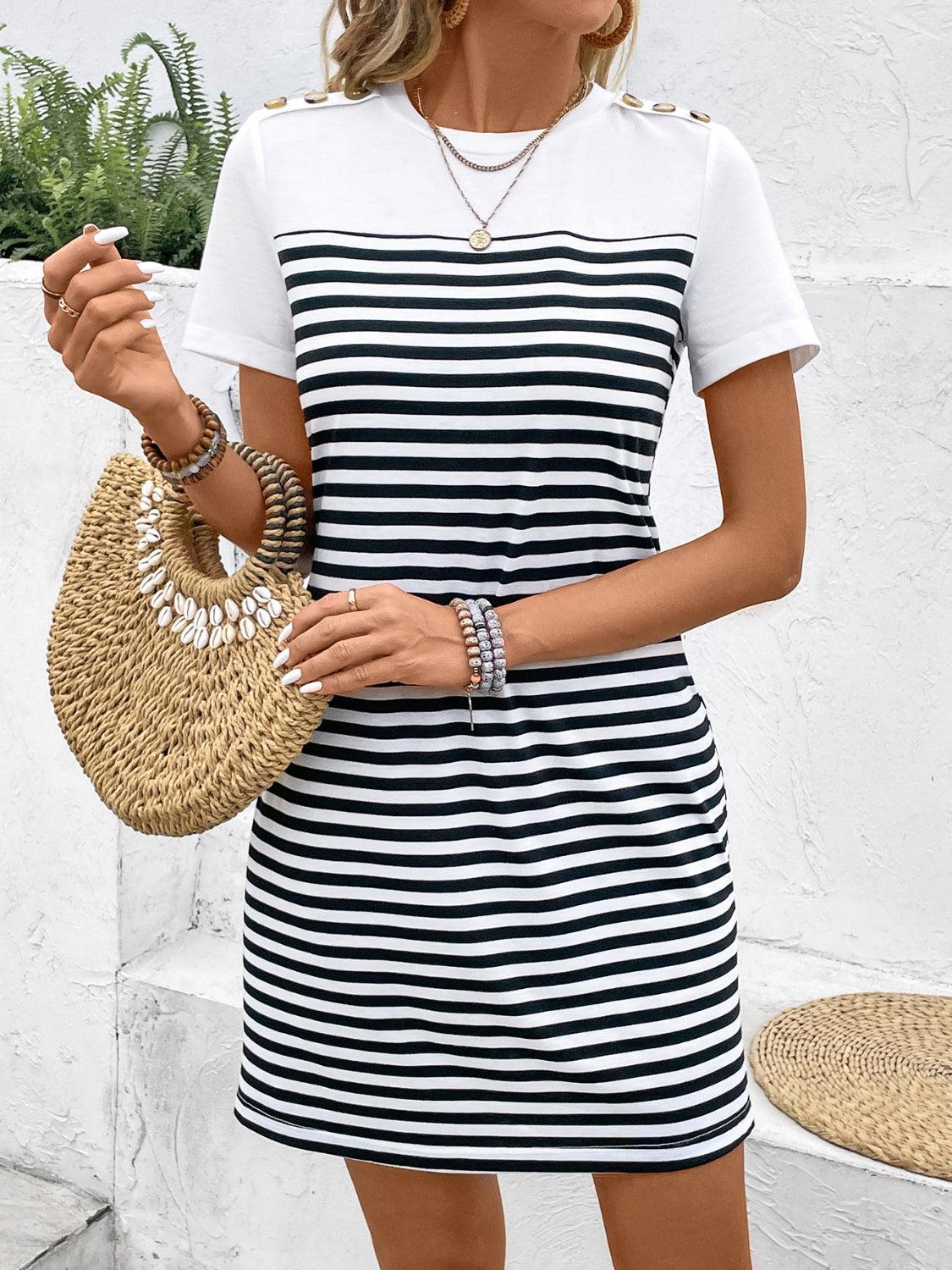 a woman in a striped dress holding a straw bag