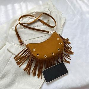 a brown purse sitting on top of a white bed