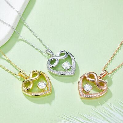 three heart shaped pendants on a green surface