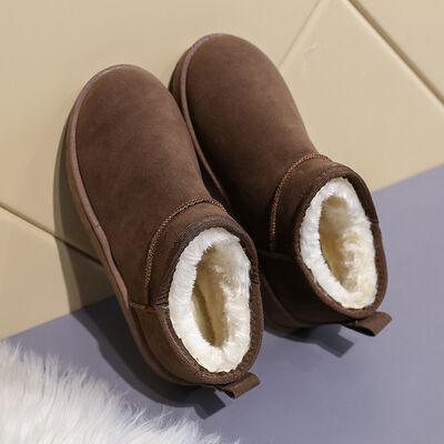 a pair of brown slippers sitting on top of a white rug