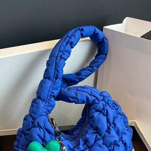 a blue purse sitting on top of a wooden table