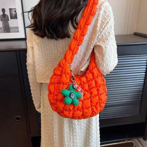 a woman in a white dress is holding an orange purse