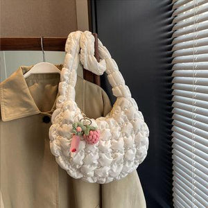 a white purse hanging on a coat rack