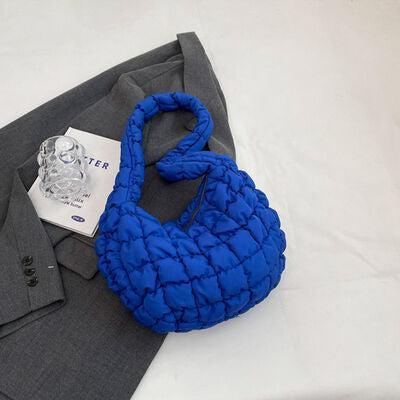 a blue purse sitting on top of a gray suit