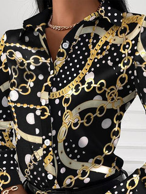 a woman wearing a black and white shirt with gold chains on it