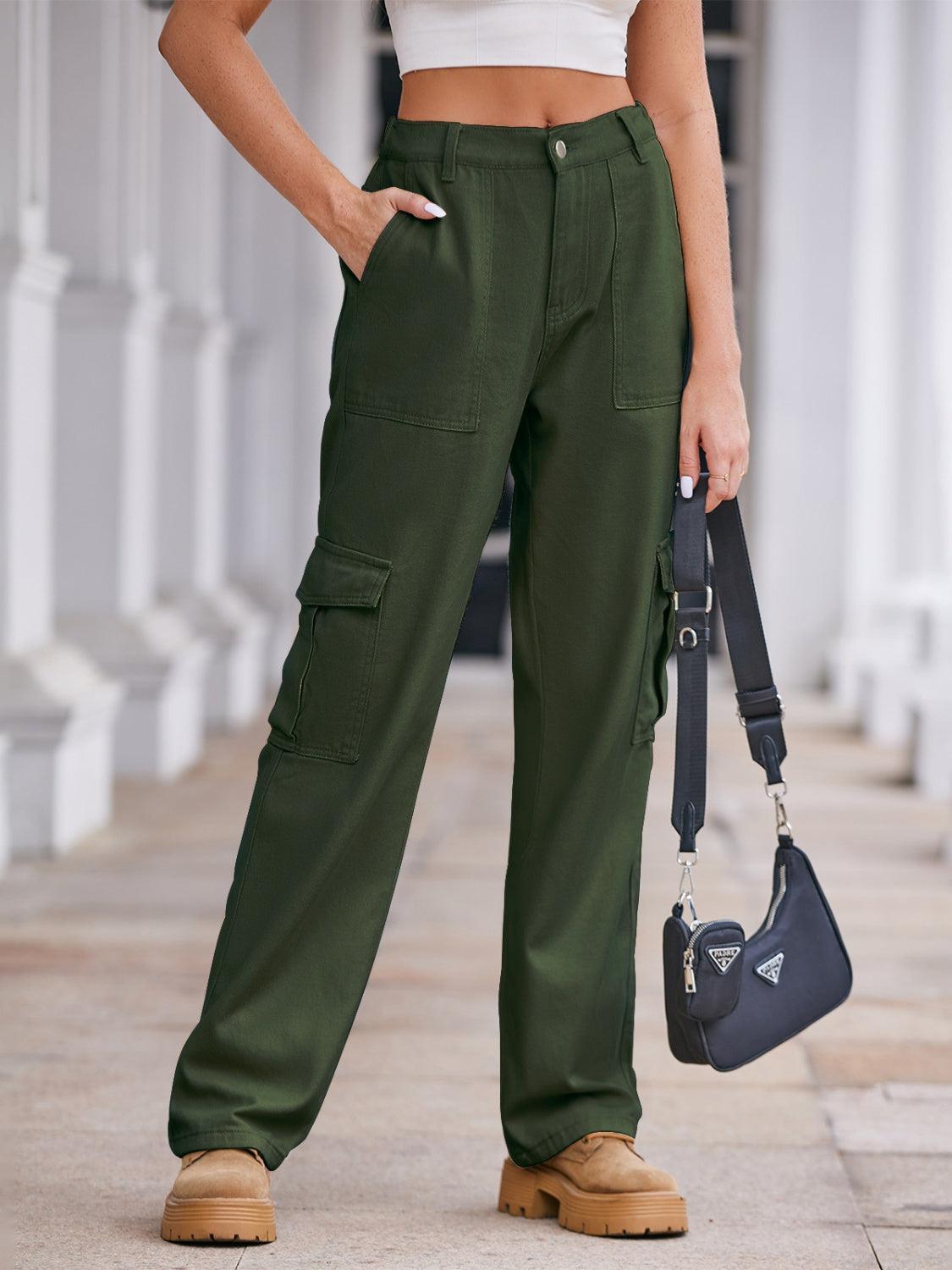 a woman wearing green pants and a white top