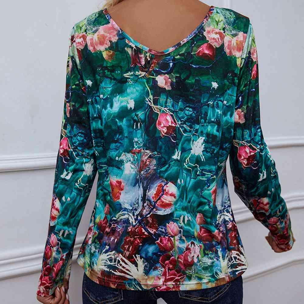 a woman wearing a floral top with long sleeves