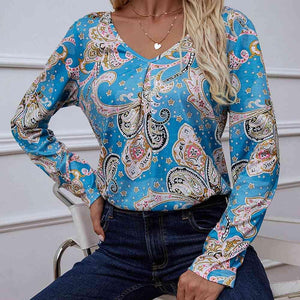 a woman sitting on a chair wearing a blue top