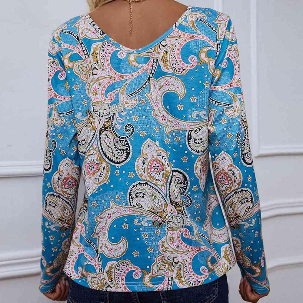 a woman wearing a blue top with a paisley pattern