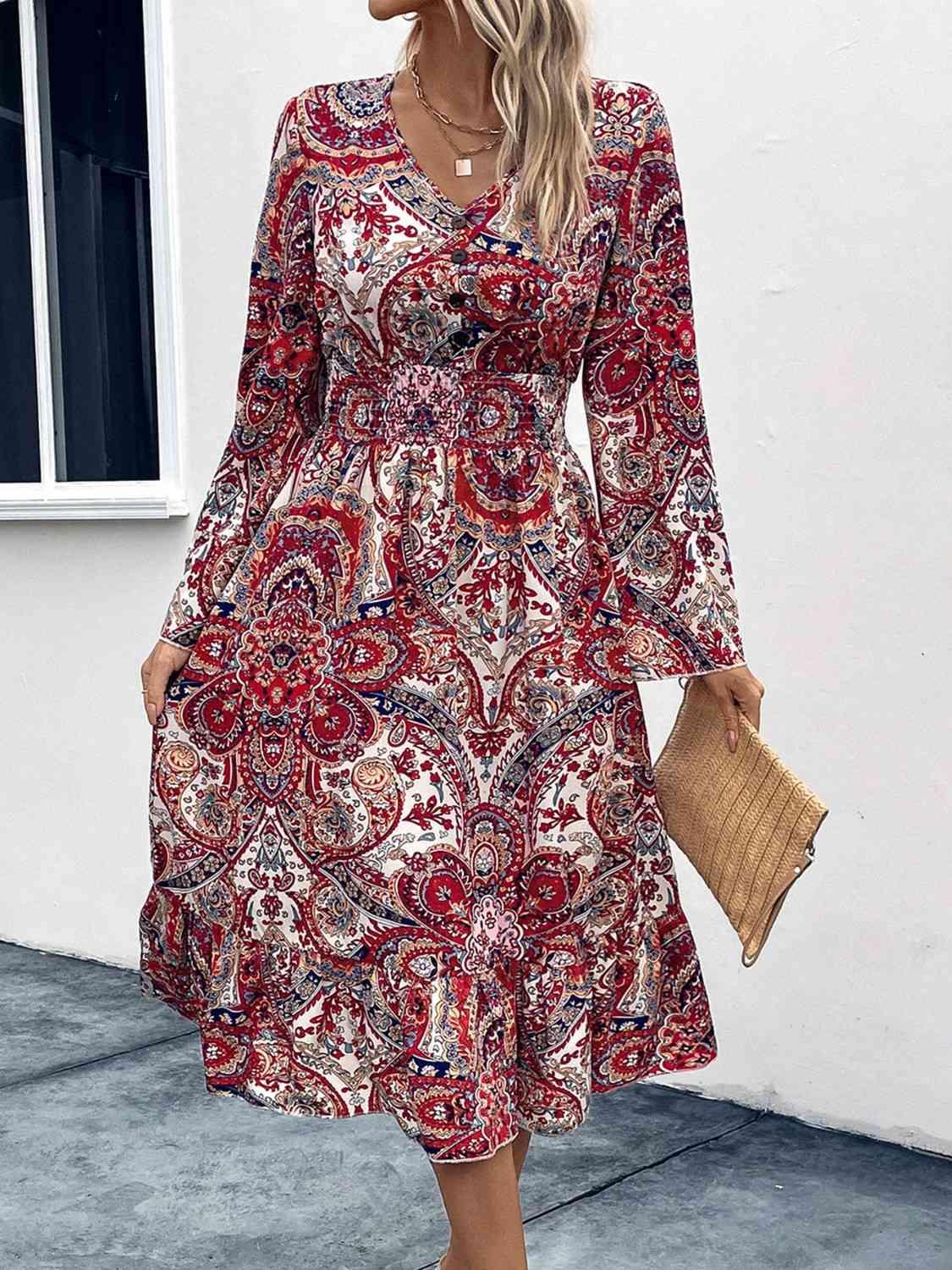 a woman wearing a red paisley print dress