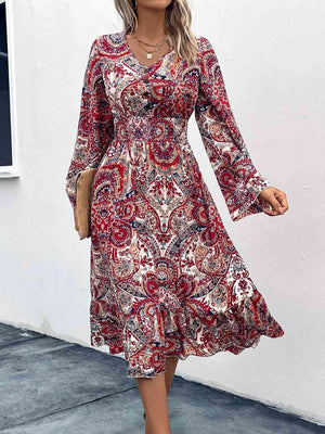 a woman wearing a red paisley print dress