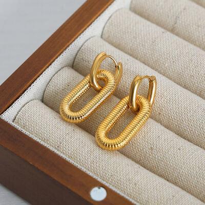 a pair of gold earrings sitting in a box