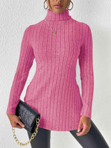 a woman wearing a pink sweater and black pants