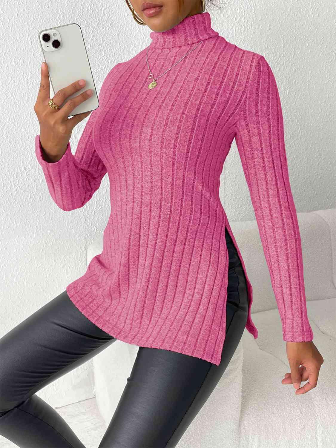 a woman in a pink sweater holding a cell phone