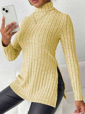 a woman in a yellow sweater holding a cell phone