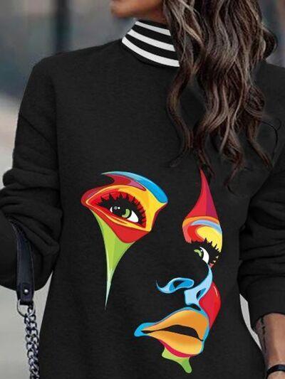 a woman wearing a black sweater with a colorful face on it