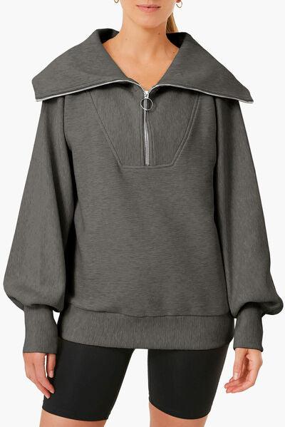 a woman wearing a gray sweatshirt with a hoodie